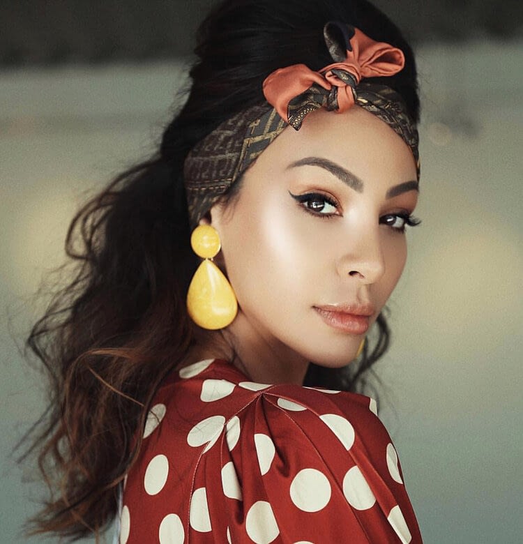 model closeup red polka dot shirt yellow earrings headband with bow